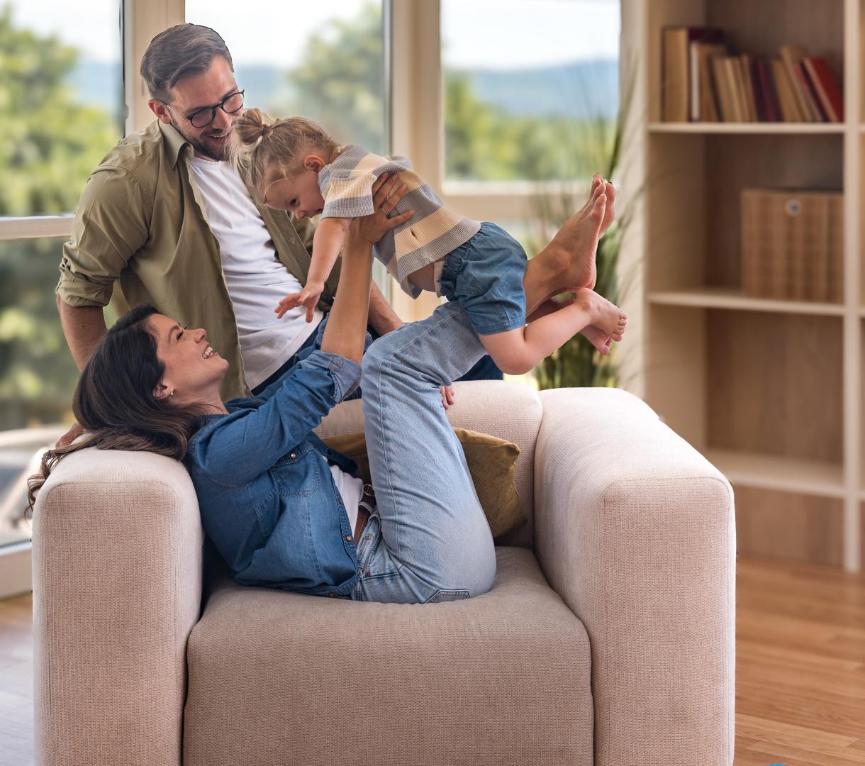 A mother, father, and child playing while moving into their new place